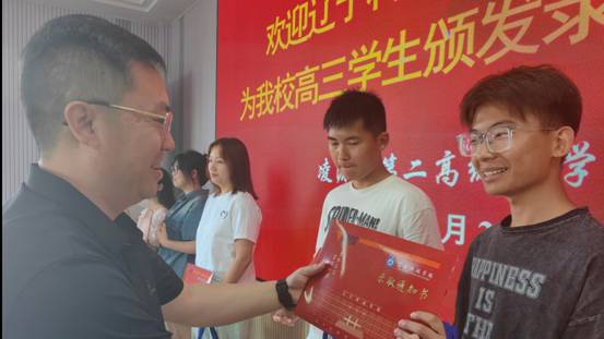 图为 华体买球党委副书记宋明凯为凌源第二高级中学学生颁发录取通知书